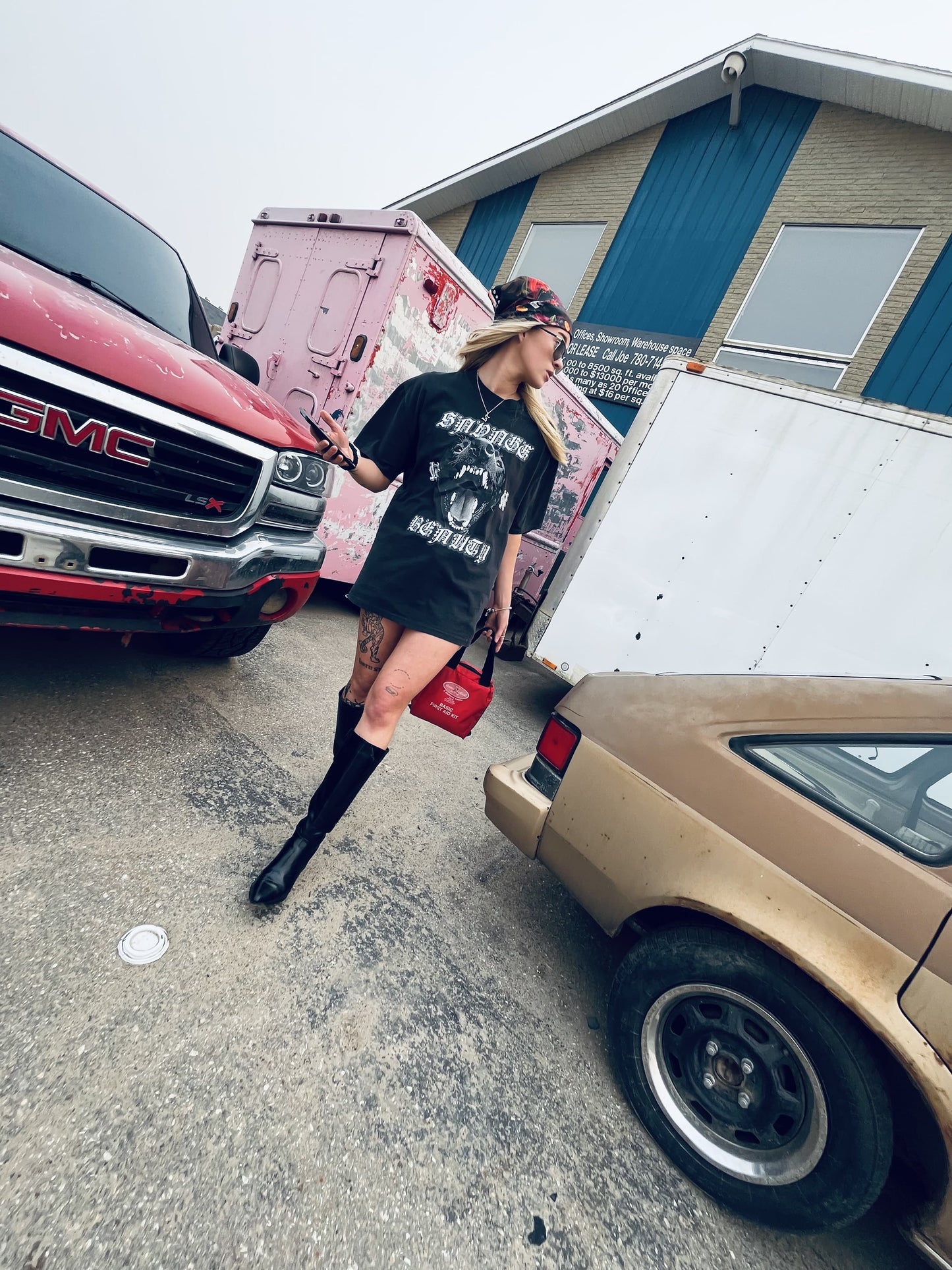 Street-style shot of Wolves Cry Savage Beauty Tee worn as a statement look with boots and scarf between vintage vehicles