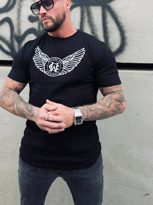 Male model wearing Wolves Cry Flight Academy Tee in black with wings graphic — close-up streetwear look, 100% cotton heavyweight t-shirt, athletic build, urban fashion.