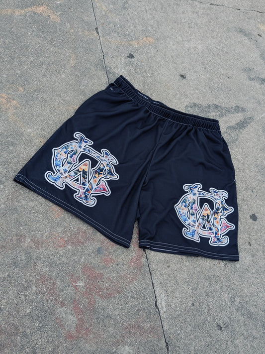 Black WC Shadow Floral Mesh Shorts with full-color gothic logos in outdoor flat lay on concrete