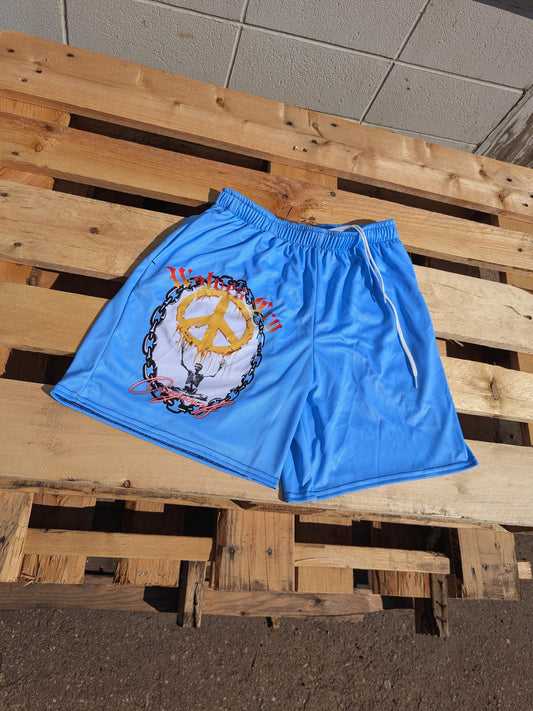 Flat lay of Wolves Cry Endless Peace Organic Mesh Shorts in Baby Blue — soft mesh build with bold peace symbol artwork on the leg.
