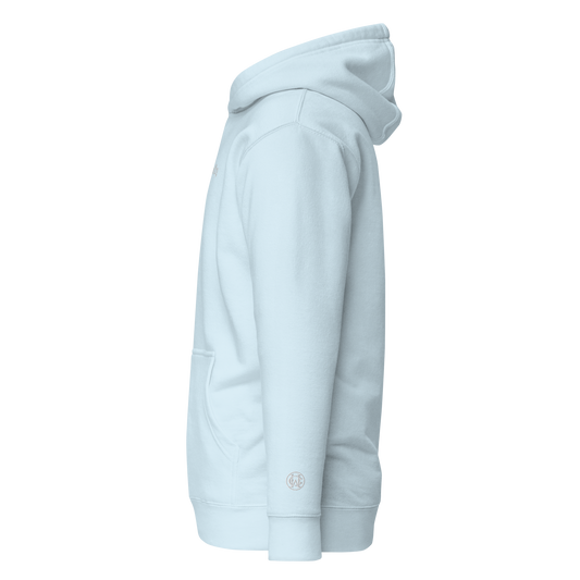 Side angle of baby blue Wolves Cry Hoodie showing clean white WC wrist monogram embroidery — soft, elevated minimalism.