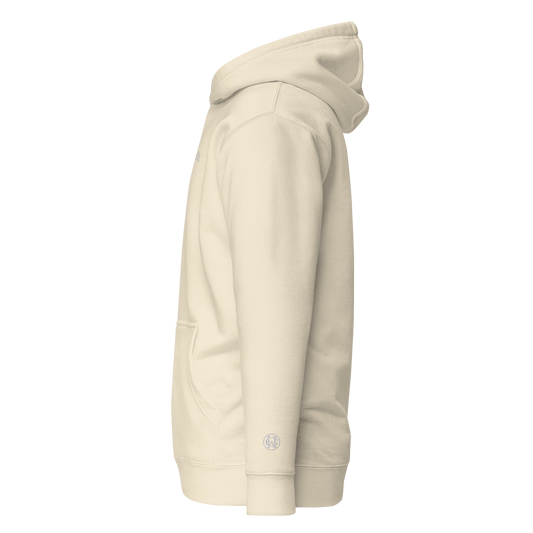 Side angle of Wolves Cry Everyday Hoodie in oatmeal, showing low-wrist WC monogram embroidery detail.
