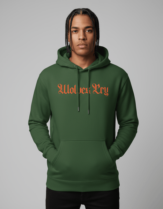Model wearing Wolves Cry Everyday Spellout Hoodie in forest green with orange embroidery — blending athletic confidence with bold street energy.