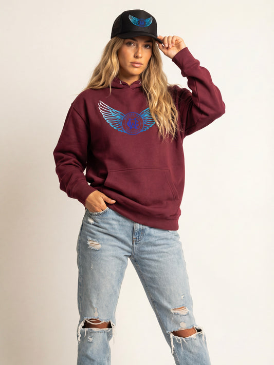 Person wearing a maroon hoodie with a blue logo and light blue jeans on a beige background
