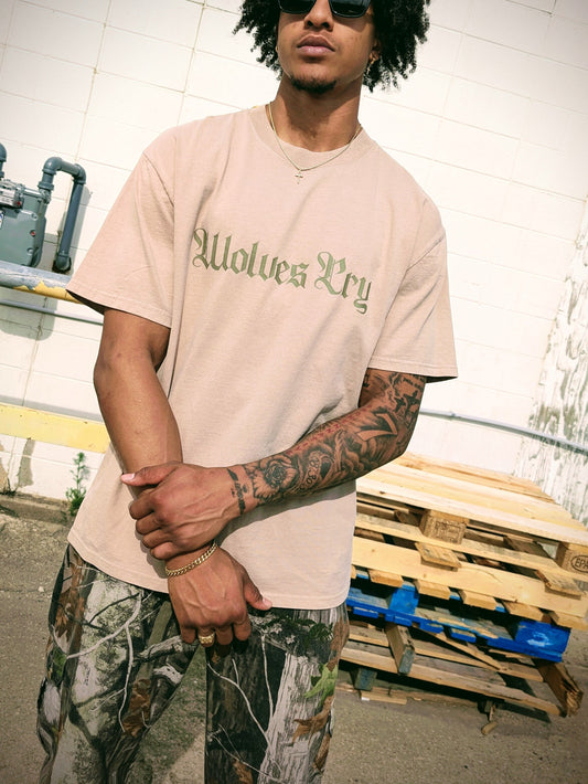 Model wearing Wolves Cry Oversized Khaki Vintage Tee with olive camo lettering — relaxed drape and rugged tonal street aesthetic.