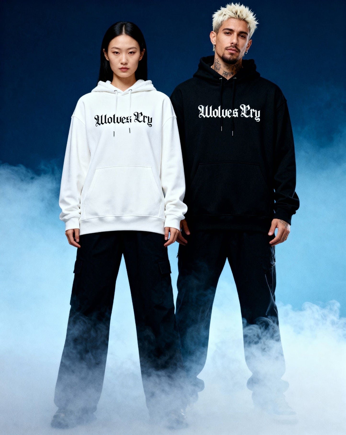 Two models wearing wolves cry originals hoodies in white and black, standing against a blue gradient background- modern Canadian streetwear essentials 
