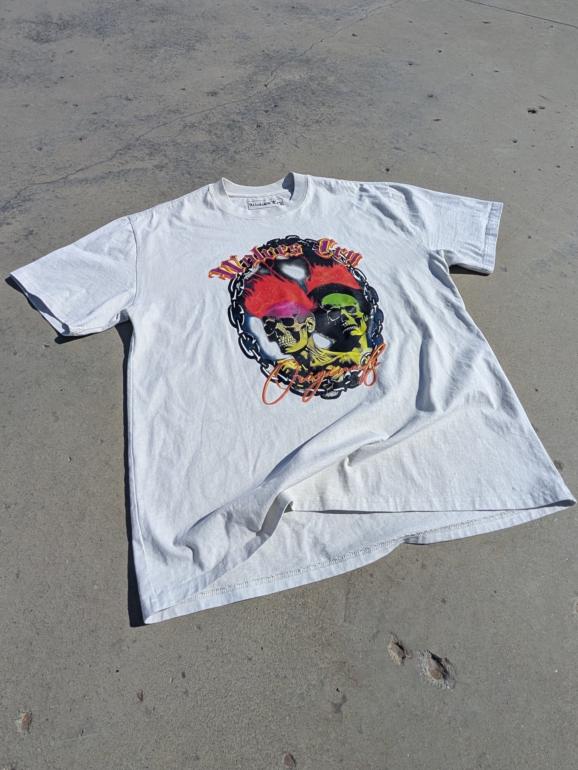 Oversized Megadeath Tee in Bone by Wolves Cry Originals, laid flat in natural sunlight. Features bold skull flame artwork on washed cotton for a vintage look.