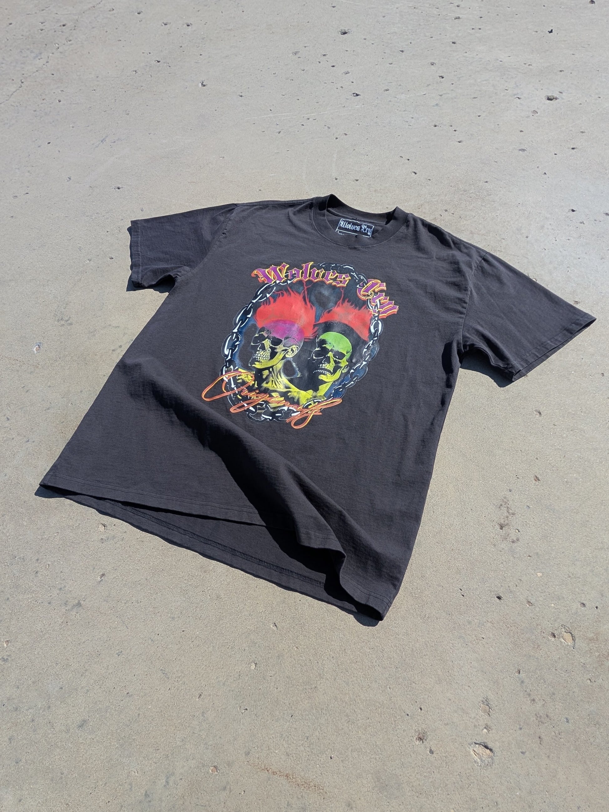 Oversized Megadeath Tee in Vintage Black by Wolves Cry Originals, flatlay under direct sunlight. Washed heavyweight cotton with neon skull flame print.