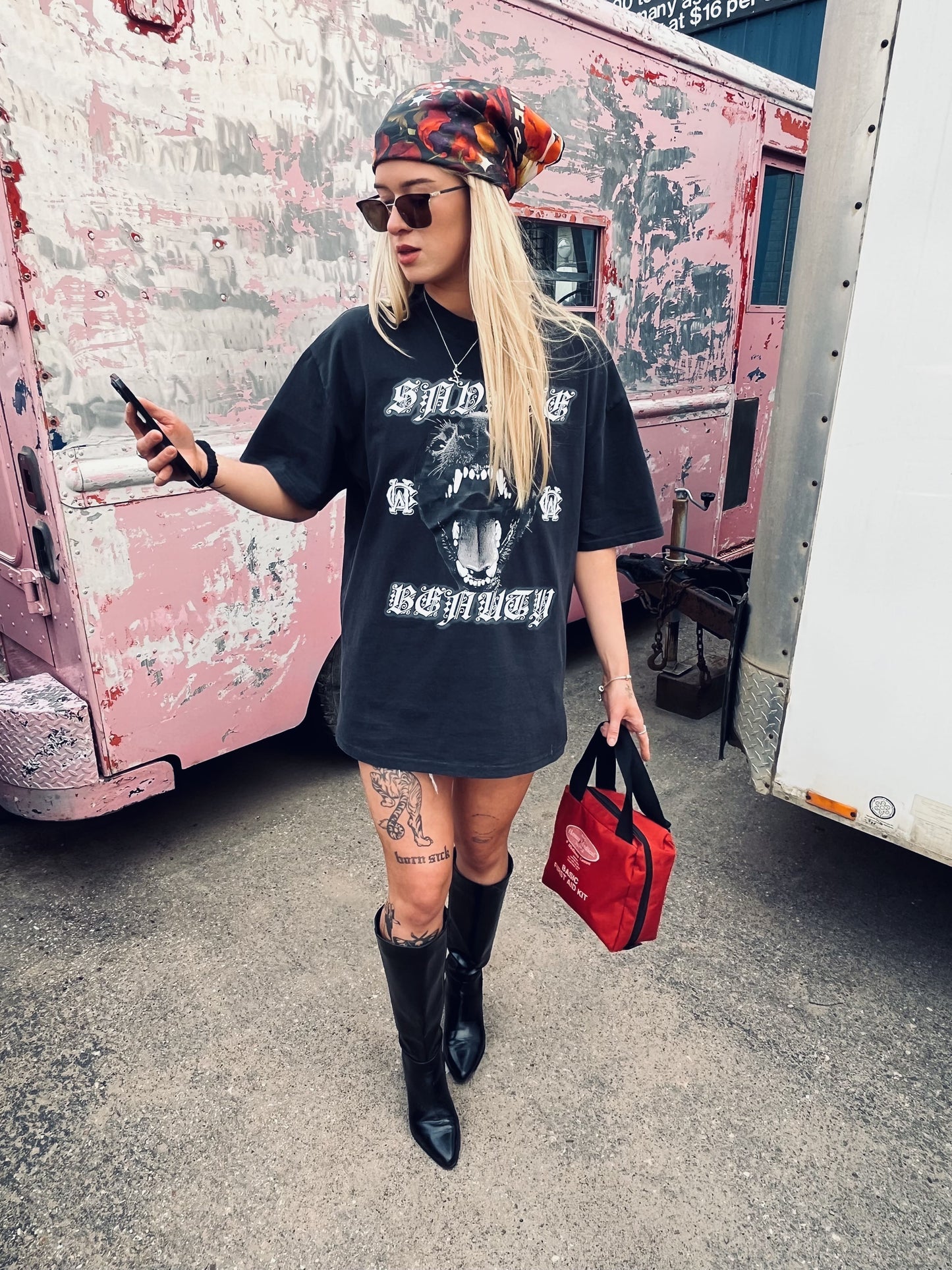 Female model styles Wolves Cry Savage Beauty Tee oversized as a dress with silk headscarf, boots, and red bag
