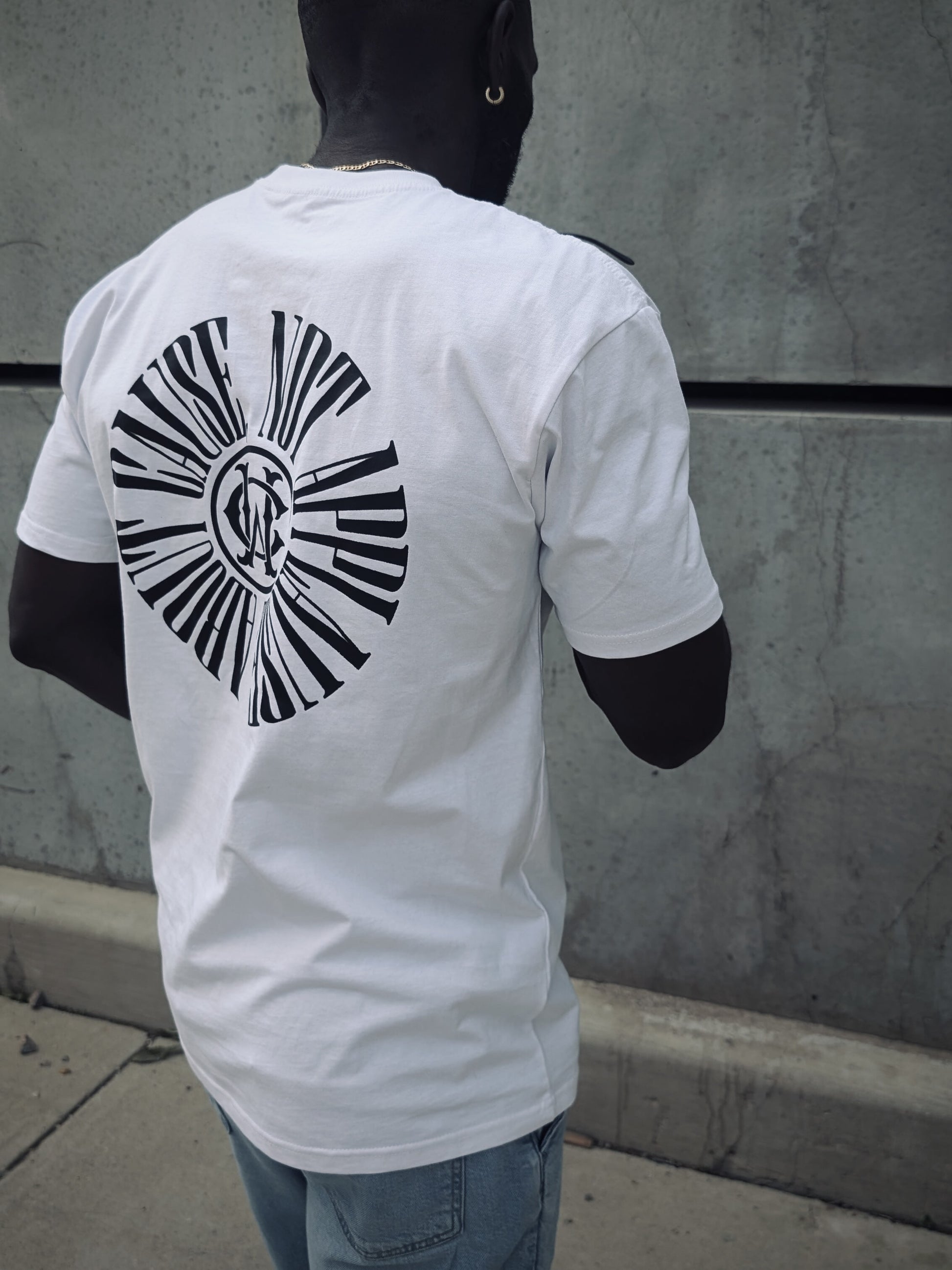 Back view of Wolves Cry tee in motion, displaying bold graphic “About Cause Not Applause” print