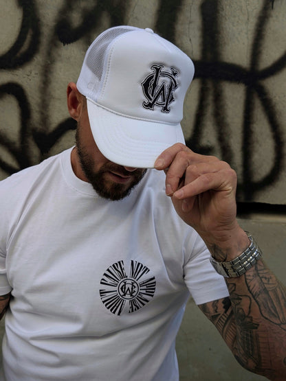 White WC foam trucker hat styled with graphic tee — streetwear look featuring black embroidered monogram
