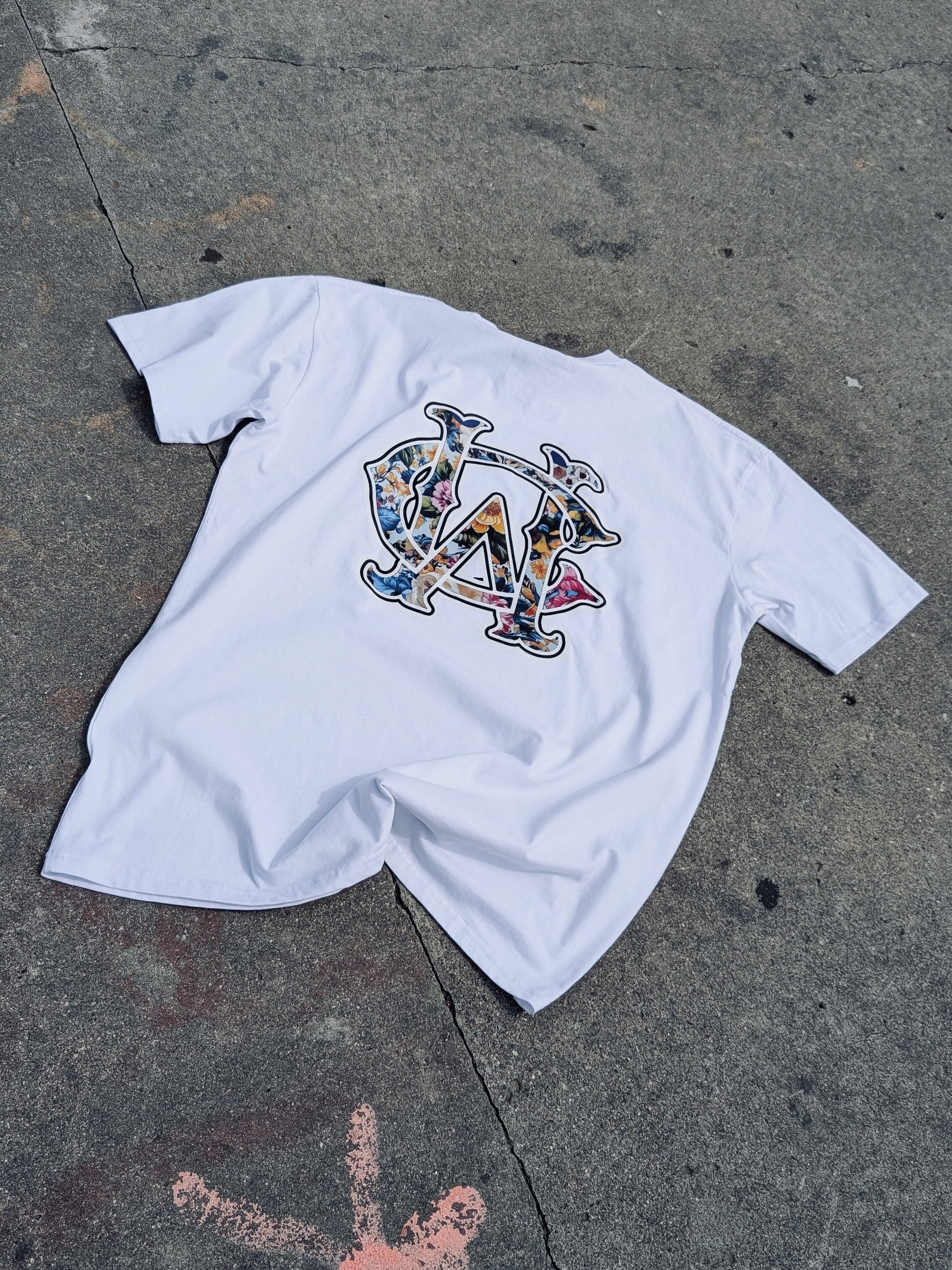 WC Shadow Floral Tee back flat lay in white showing detailed floral WC monogram