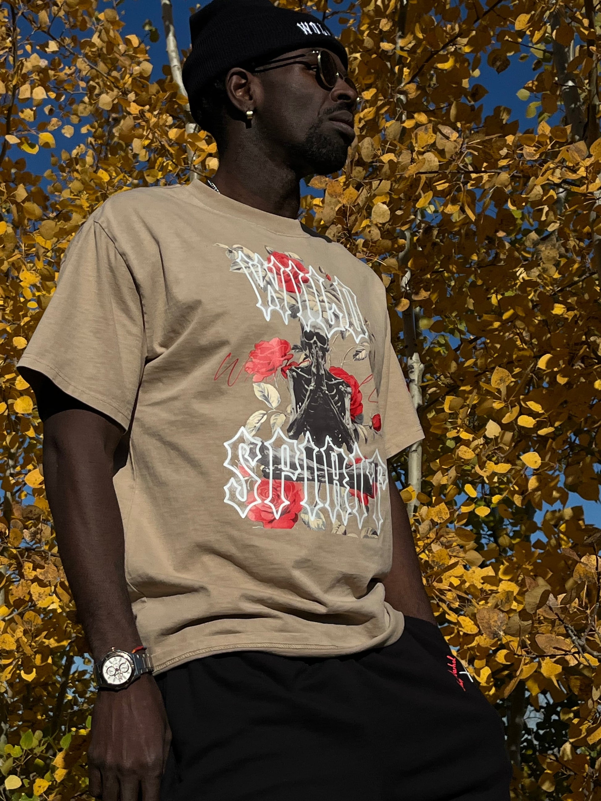 Side profile of male model wearing the Wild Spirit Prayer Tee in khaki, showcasing the oversized fit and intricate floral skeleton design.