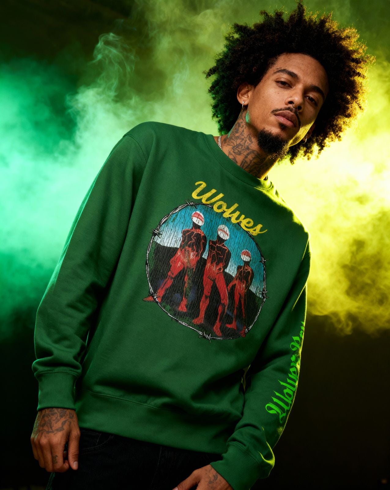 Model wearing Wolves Cry Descendants crewneck in forest green, styled with moody stage lighting — vintage band-era streetwear aesthetic.