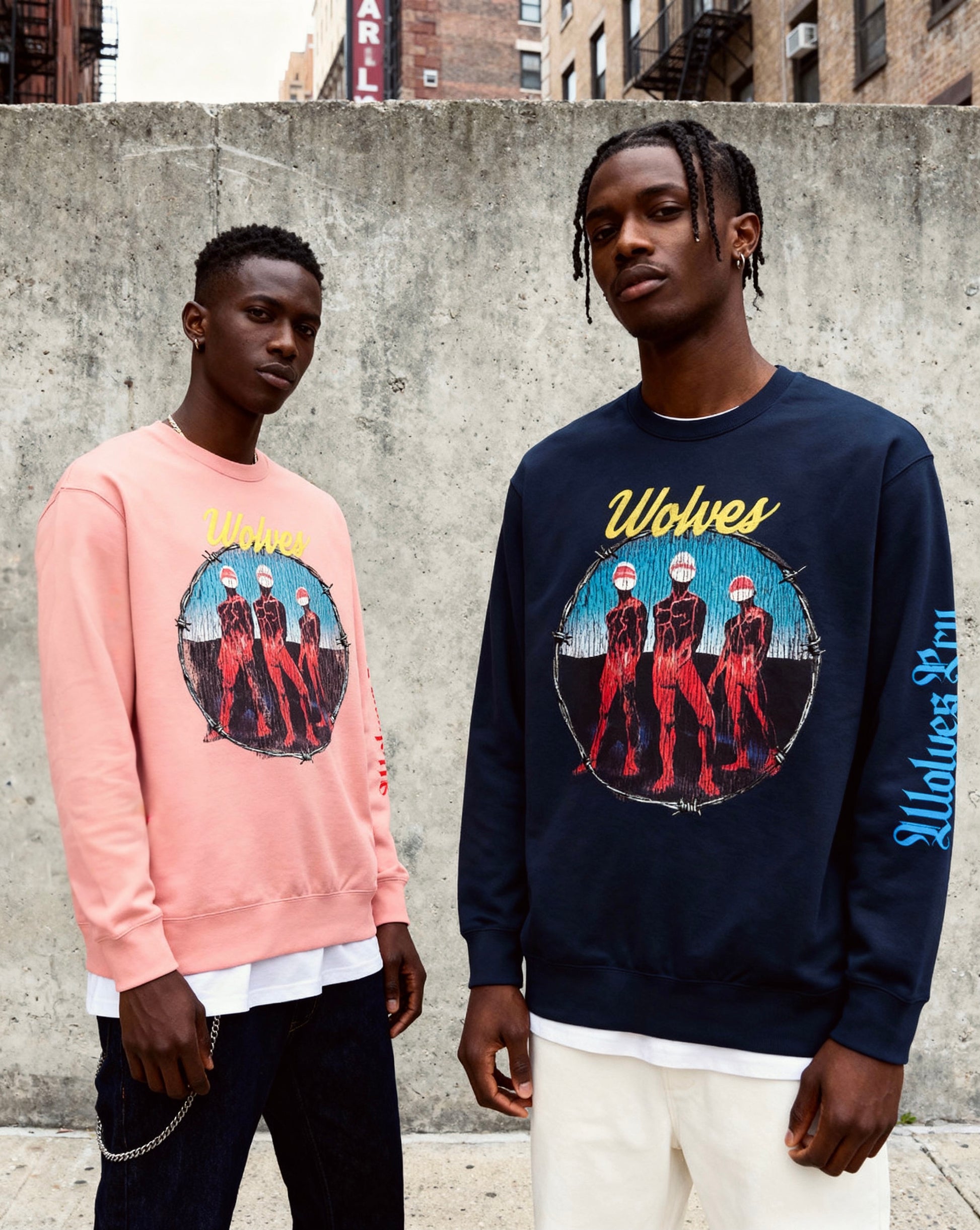 Streetwear lifestyle shot featuring two models wearing Wolves Cry crewnecks, highlighting the Descendants navy colorway in an urban setting.