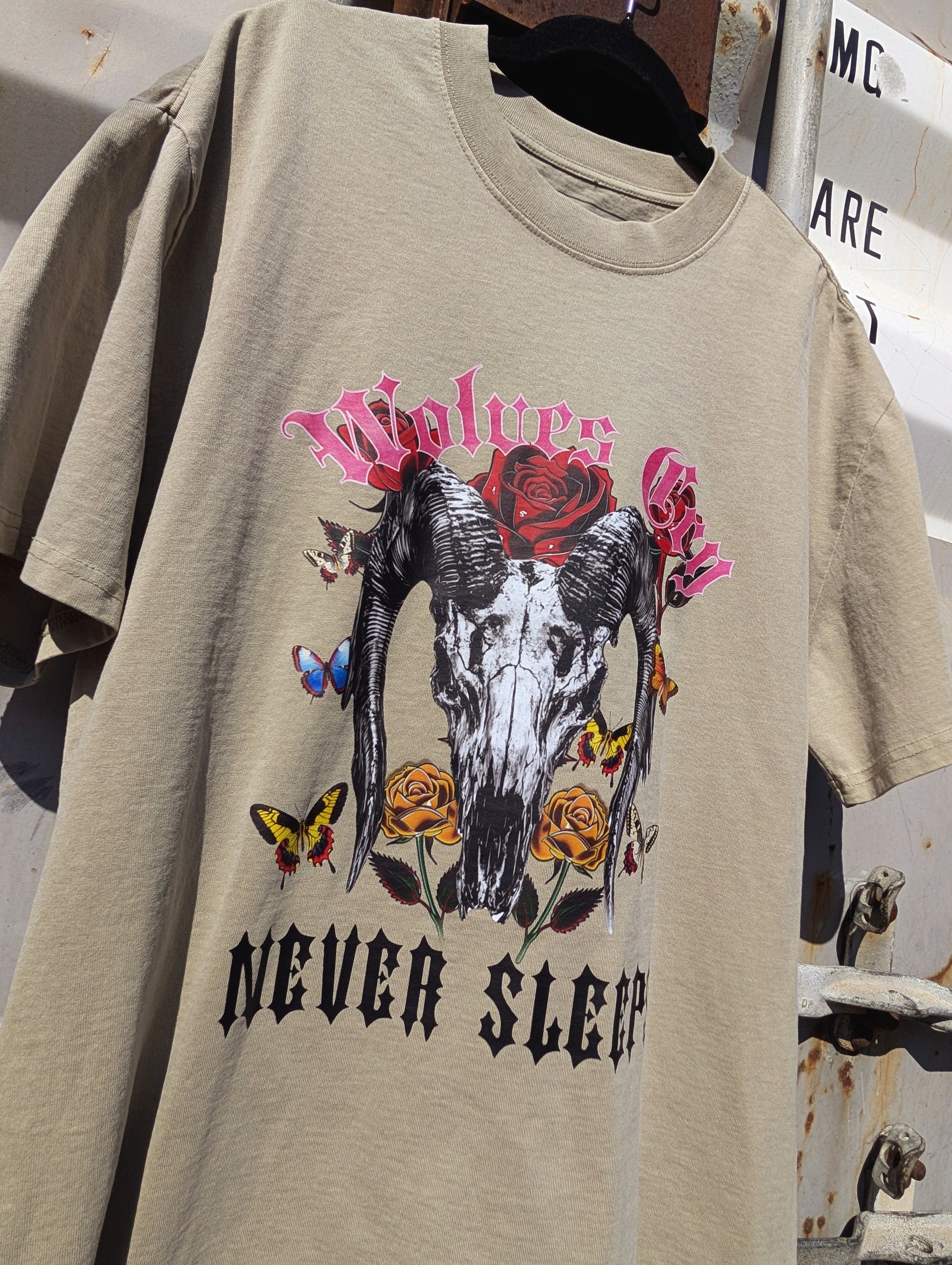 Close-up of Wolves Cry DVNS Tee in sage green showing weathered skull and rose print — faded vintage texture with Wolves Cry’s bold character.