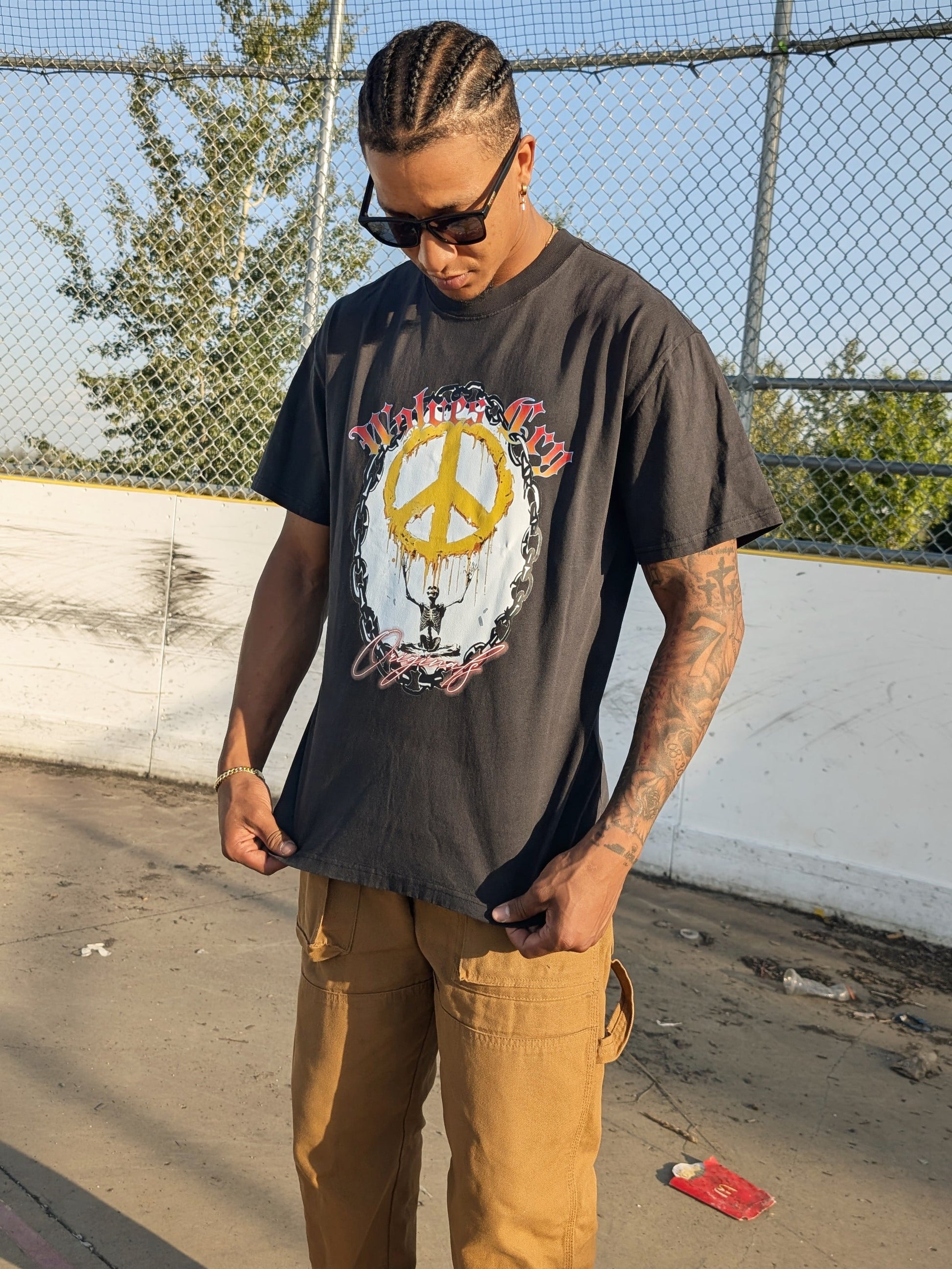 Model wearing Wolves Cry Endless Peace Tee in black vintage — faded tone, oversized cut, and rebellious energy captured through bold graphic detail.
