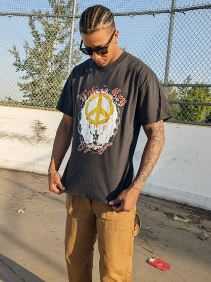 Model wearing Wolves Cry Endless Peace Tee in black vintage — faded tone, oversized cut, and rebellious energy captured through bold graphic detail.