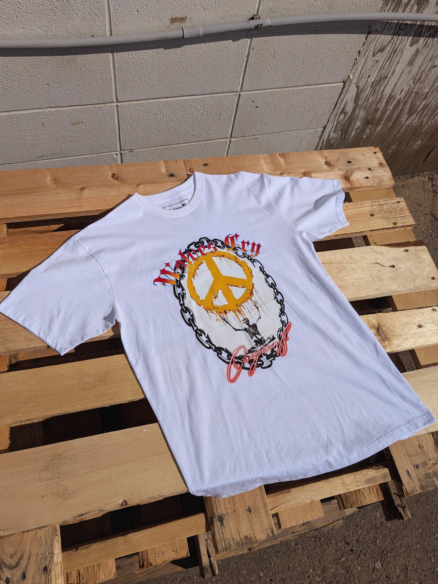 Top-view flat lay of Wolves Cry Endless Peace Tee in white, showing front print detail of peace-skull design and signature Wolves Cry lettering.