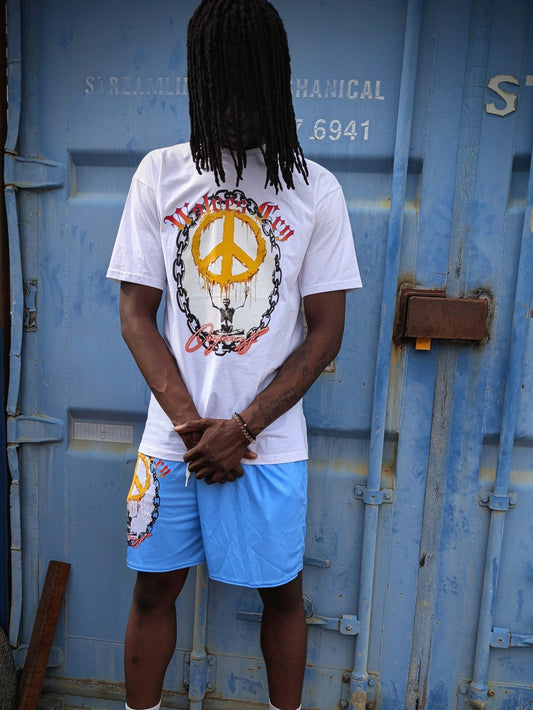 Lifestyle photo of Wolves Cry Endless Peace Tee in white, worn outdoors beside blue industrial doors — bold peace-skull artwork framed in roses, symbolizing strength and serenity in everyday rebellion.