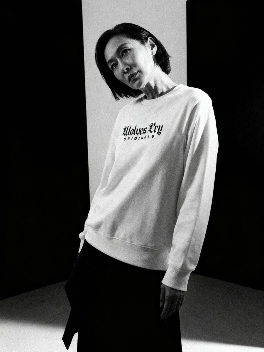Model wearing Wolves Cry Embroidered Plain Jane Crew in white, styled with relaxed streetwear fit under clean studio lighting.