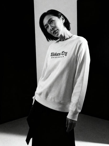 Model wearing Wolves Cry Embroidered Plain Jane Crew in white, styled with relaxed streetwear fit under clean studio lighting.