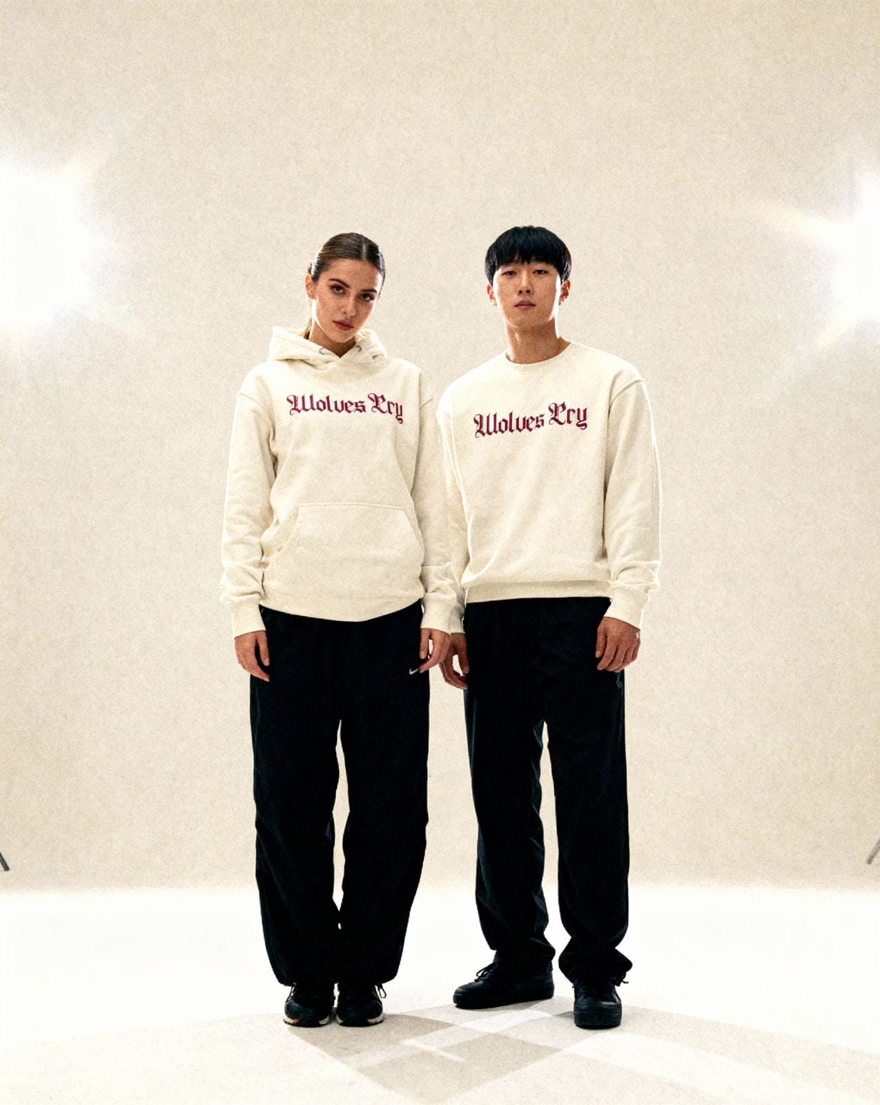 Two models wearing Wolves Cry Everyday Spellout Hoodie in oatmeal and merlot — casual yet elevated street uniform energy.