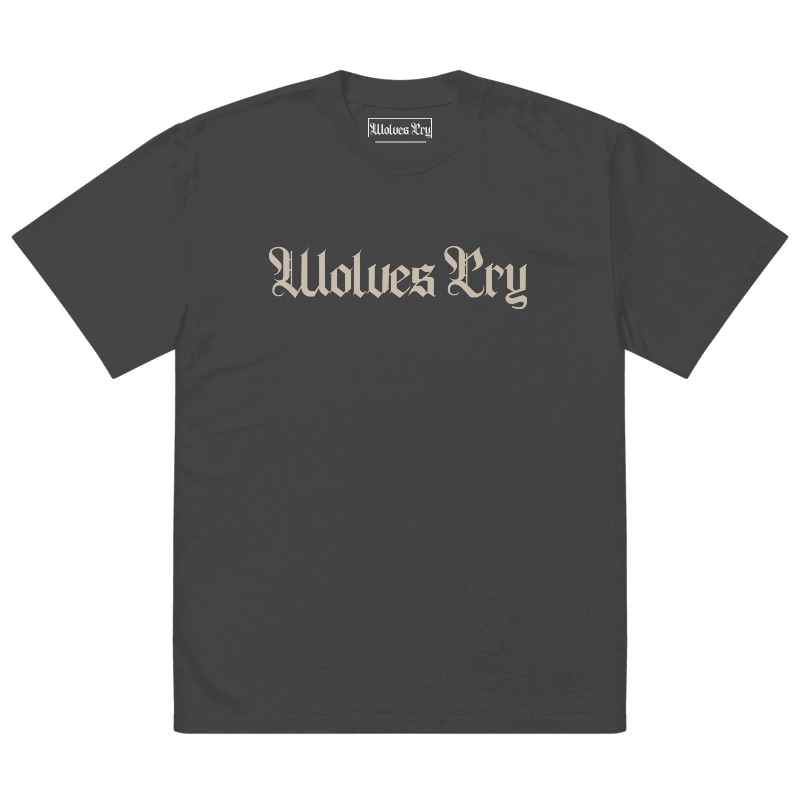 Front view of Wolves Cry Oversized Vintage Wash Tee in black with cream camo spell-out logo — classic, worn-in street uniform energy.